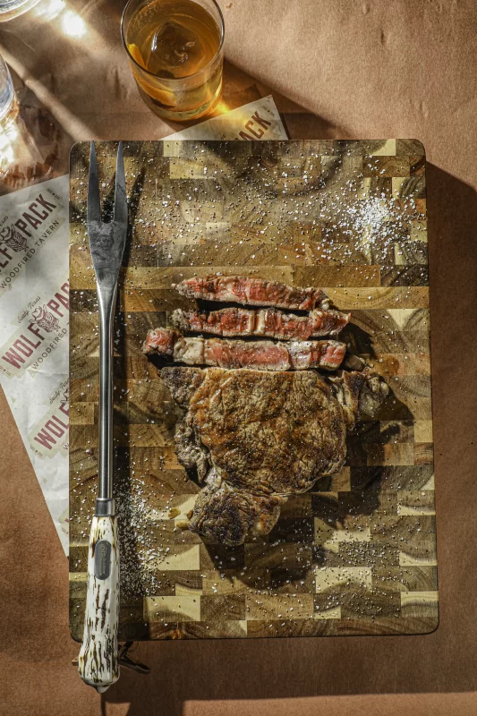 Wood-fired ribeye steak with perfect char and seasoning served at Wolfpack Woodfired Tavern in Sealy, Texas