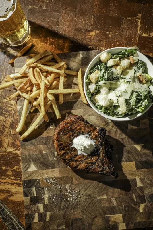 Steakhouse Thick-cut wood-fired pork chops with roasted vegetables and potatoes at Wolfpack Woodfired Tavern in Sealy, Texas